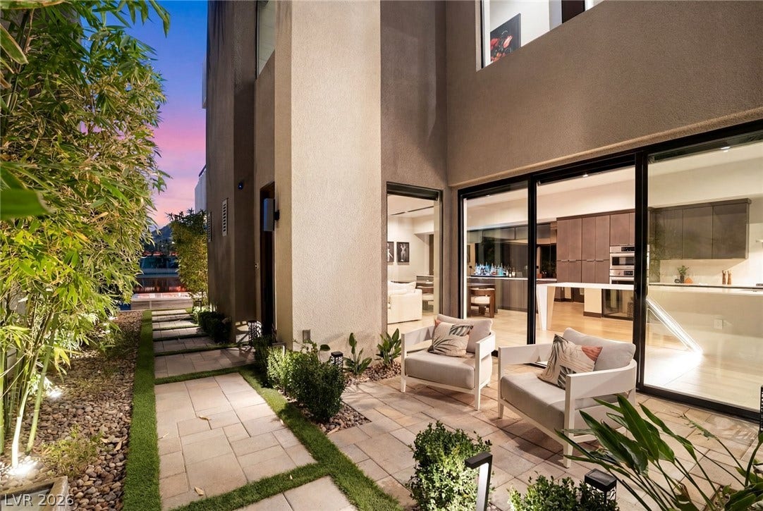 34 Lakefront Drive, Henderson, NV 89011 Sliding glass walls seamlessly connect modern interior spaces to a private paved courtyard.