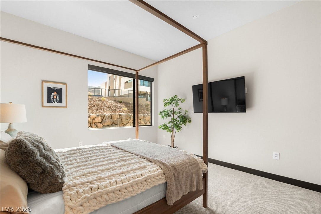 34 Lakefront Drive, Henderson, NV 89011 Plentiful natural light streams through the large window in this carpeted bedroom.