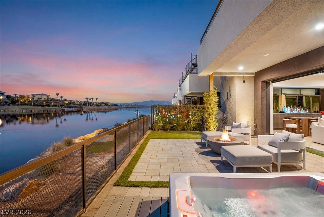 34 Lakefront Drive, Henderson, NV 89011 A spacious stone patio overlooks serene waterfront views from this custom backyard retreat.