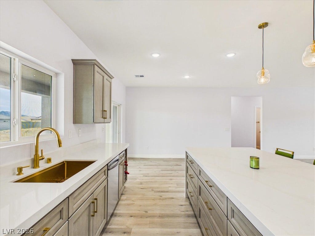6680 S Raintree Court, Pahrump, NV 89061 Elegant stone countertops and custom cabinetry define this modern open kitchen.