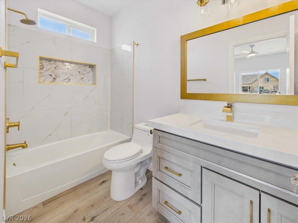 6680 S Raintree Court, Pahrump, NV 89061 Elegant gold hardware pairs beautifully with a modern vanity and tiled alcove tub.