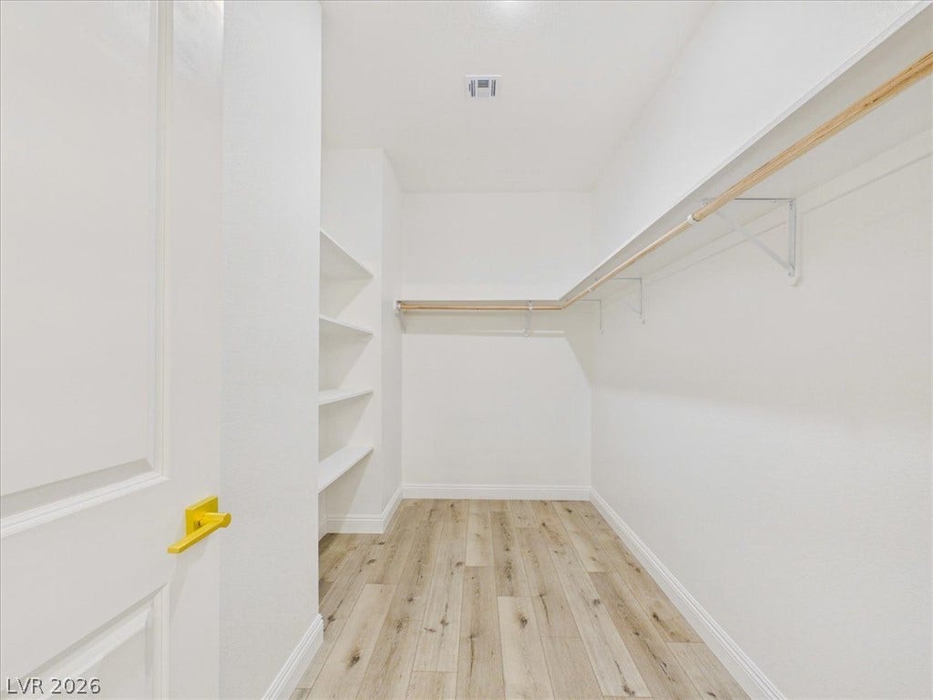 6680 S Raintree Court, Pahrump, NV 89061 Ample built-in shelving and hanging rods maximize storage in this wood-floored closet.