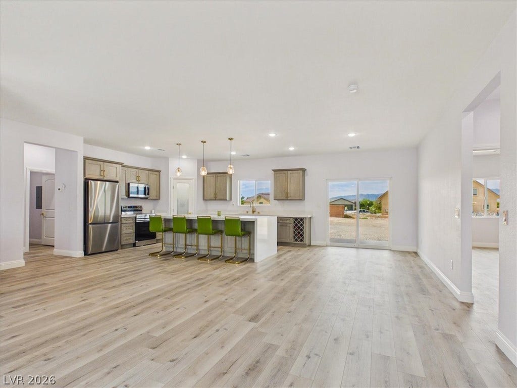 6680 S Raintree Court, Pahrump, NV 89061 Hardwood floors and an open concept layout seamlessly connect the kitchen and living spaces.