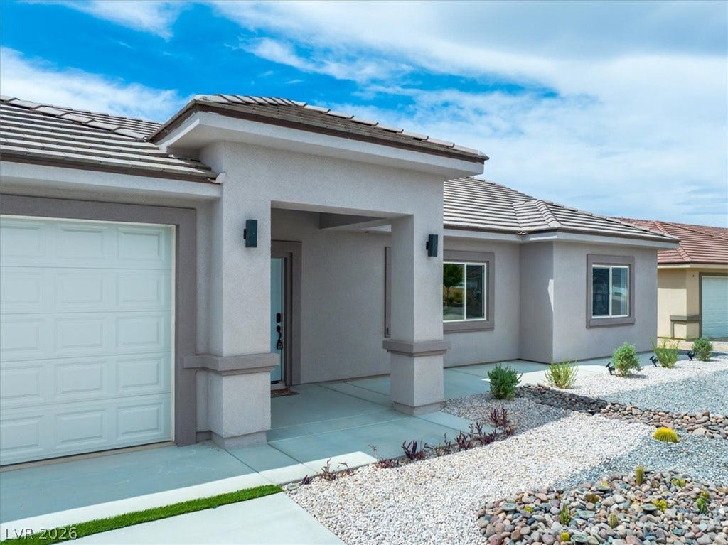 6680 S Raintree Court, Pahrump, NV 89061 An inviting covered entryway and desert landscaping welcome guests to this modern stucco home.