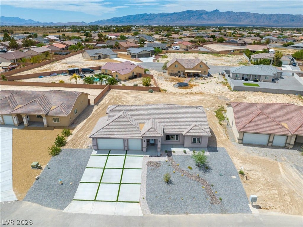 6680 S Raintree Court, Pahrump, NV 89061 An aerial perspective showcases the tile roof and modern concrete driveway of this desert home.