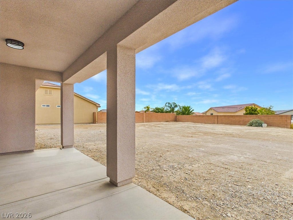 6680 S Raintree Court, Pahrump, NV 89061 A covered concrete patio provides shelter and views across the expansive enclosed backyard space.