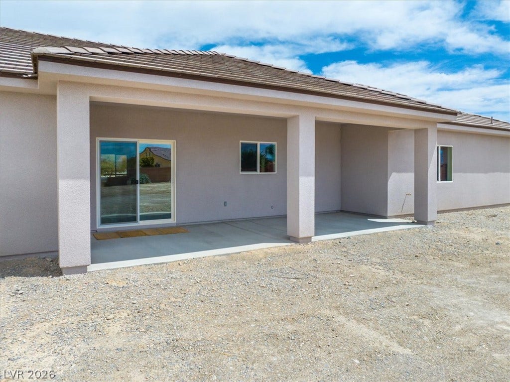 6680 S Raintree Court, Pahrump, NV 89061 A spacious covered concrete patio spans the rear of this stucco home.