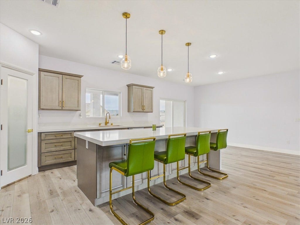 6680 S Raintree Court, Pahrump, NV 89061 Gleaming stone countertops and a spacious breakfast island anchor this contemporary, open kitchen design.