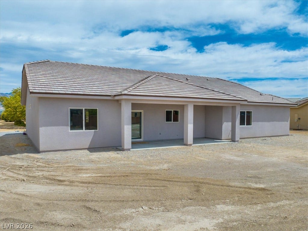 6680 S Raintree Court, Pahrump, NV 89061 A spacious covered patio anchors the rear of this stucco home under a tiled roof.