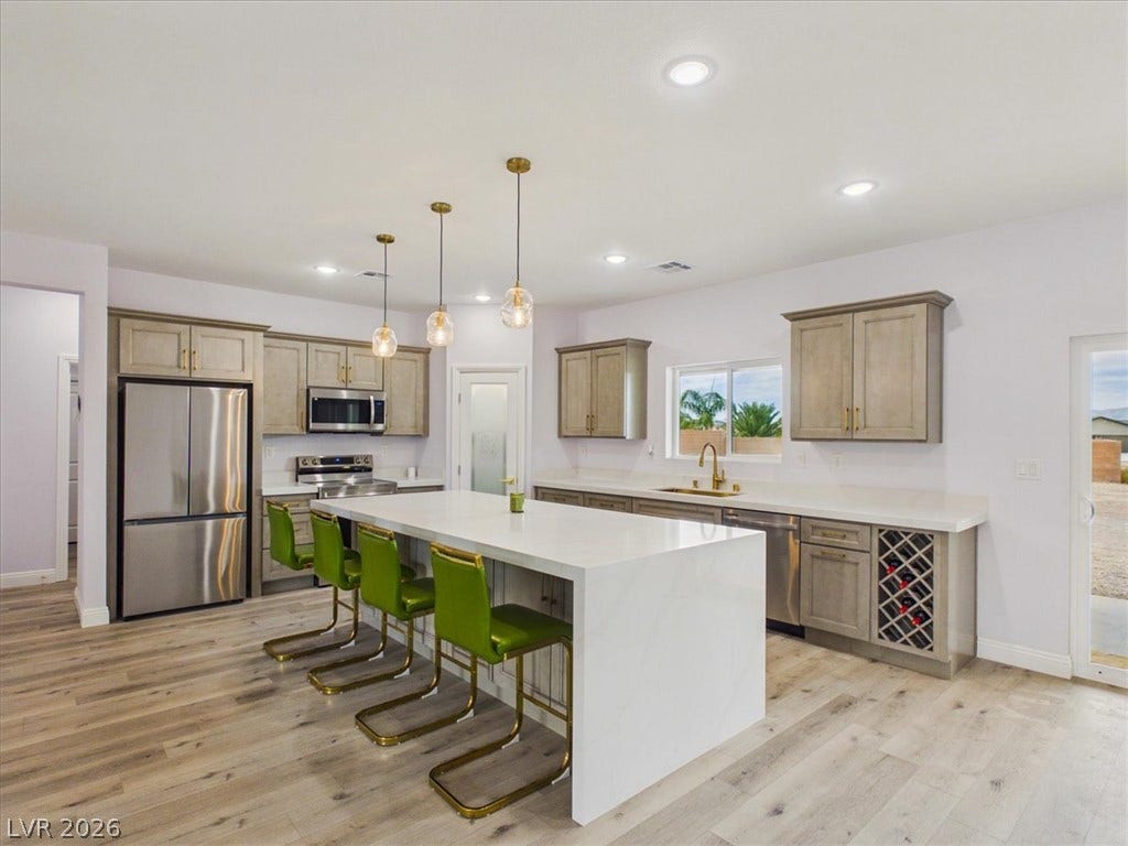 6680 S Raintree Court, Pahrump, NV 89061 Gleaming stone countertops and a spacious central island anchor this contemporary kitchen design.