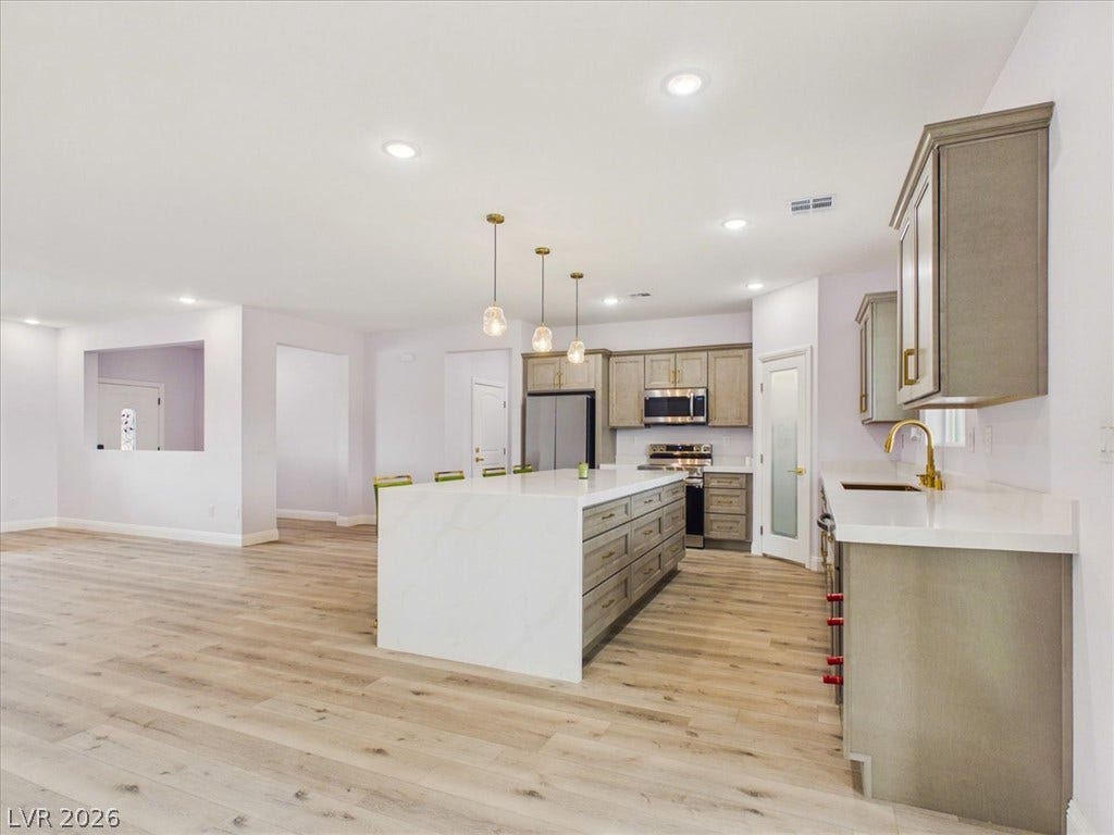 6680 S Raintree Court, Pahrump, NV 89061 Clean lines and warm wood floors define this expansive, modern culinary space.