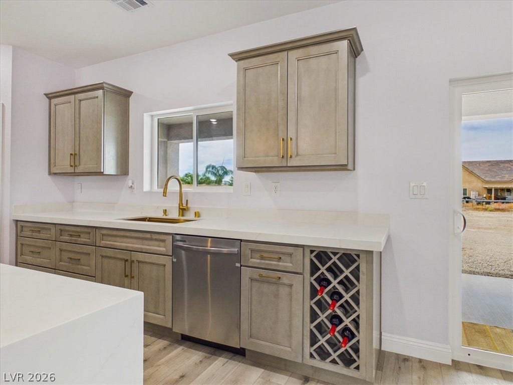 6680 S Raintree Court, Pahrump, NV 89061 Modern cabinetry and solid stone countertops frame a bright window in this kitchen design.