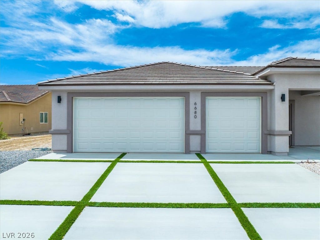 6680 S Raintree Court, Pahrump, NV 89061 Clean lines and a modern driveway frame this contemporary three-car garage facade.