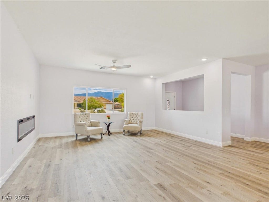 6680 S Raintree Court, Pahrump, NV 89061 Gleaming wood floors anchor a wide-open living space detailed with a contemporary inset fireplace.