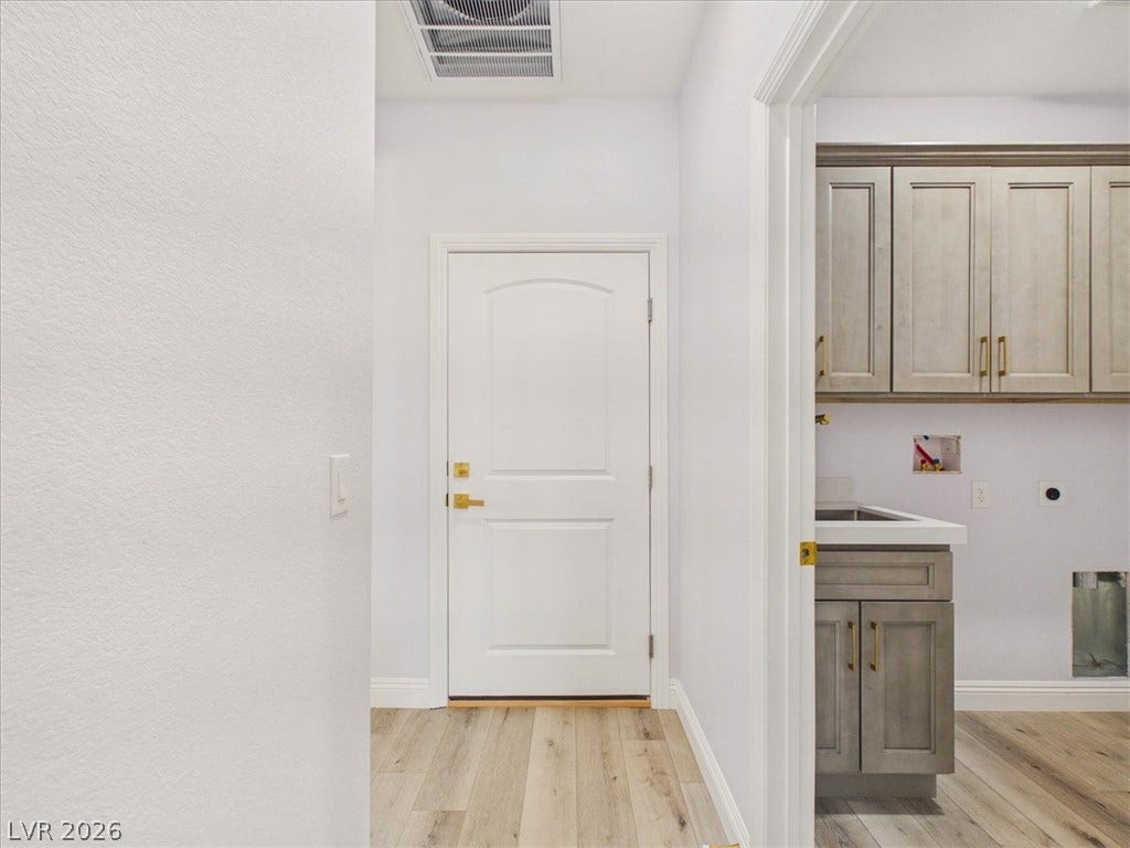 6680 S Raintree Court, Pahrump, NV 89061 Hardwood floors and crisp white trim create an inviting transition to the functional laundry room.