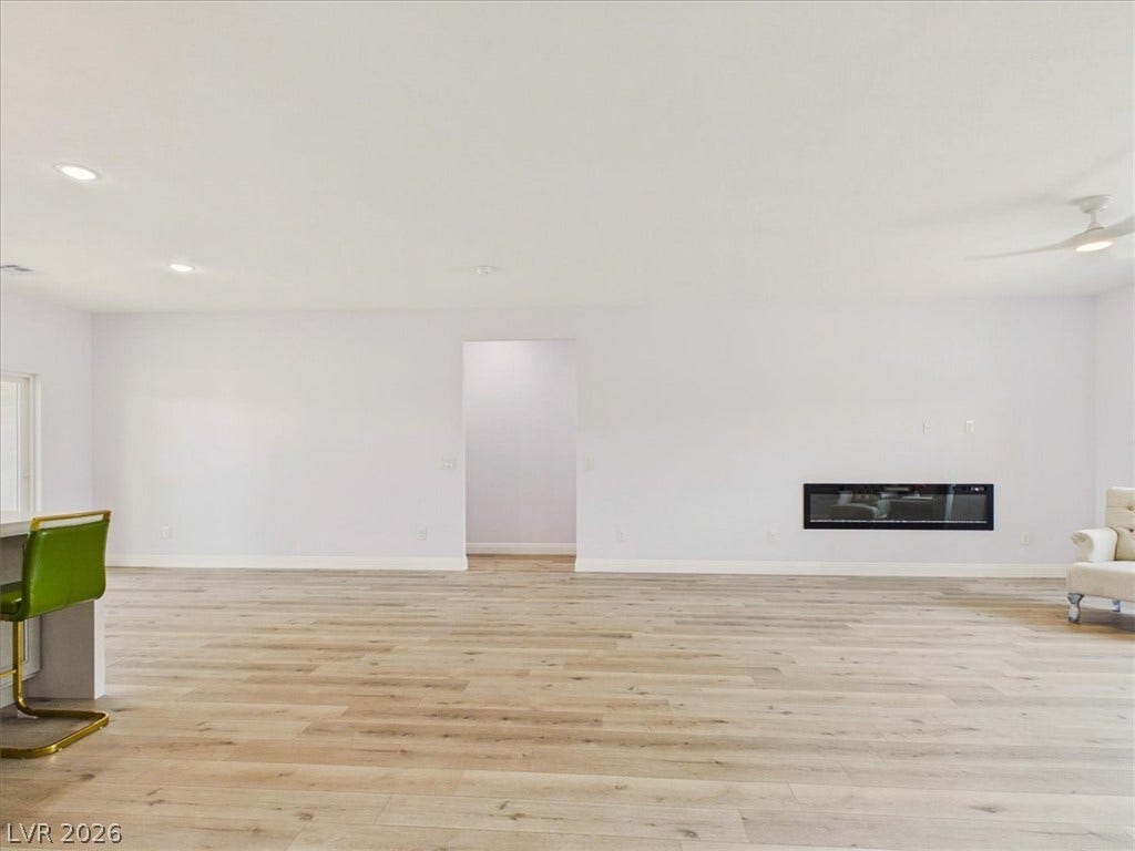 6680 S Raintree Court, Pahrump, NV 89061 Gleaming hardwood floors and a modern linear fireplace define this airy, open interior space.