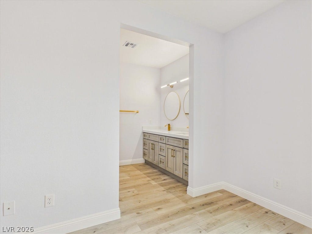 6680 S Raintree Court, Pahrump, NV 89061 An open doorway leads from the bedroom directly into the modern ensuite bathroom.