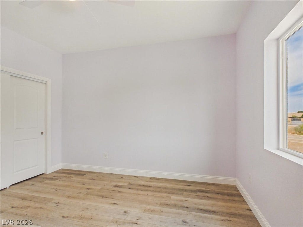 6680 S Raintree Court, Pahrump, NV 89061 Warm wood flooring and clean white walls create a serene and versatile interior space.