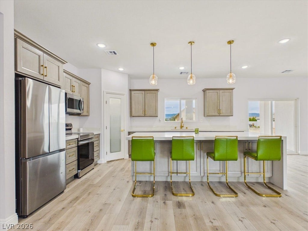 6680 S Raintree Court, Pahrump, NV 89061 Gleaming stone countertops and matching cabinetry anchor this light-filled culinary space.