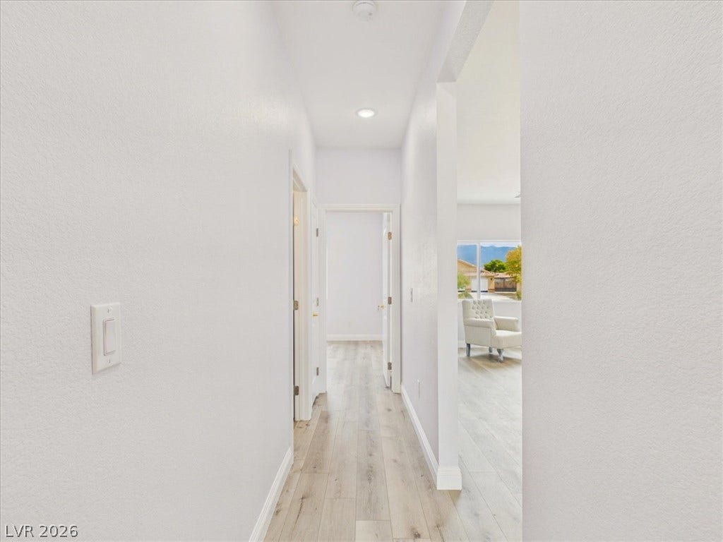 6680 S Raintree Court, Pahrump, NV 89061 Crisp white walls and clean-lined transitions define this light-filled modern hallway.