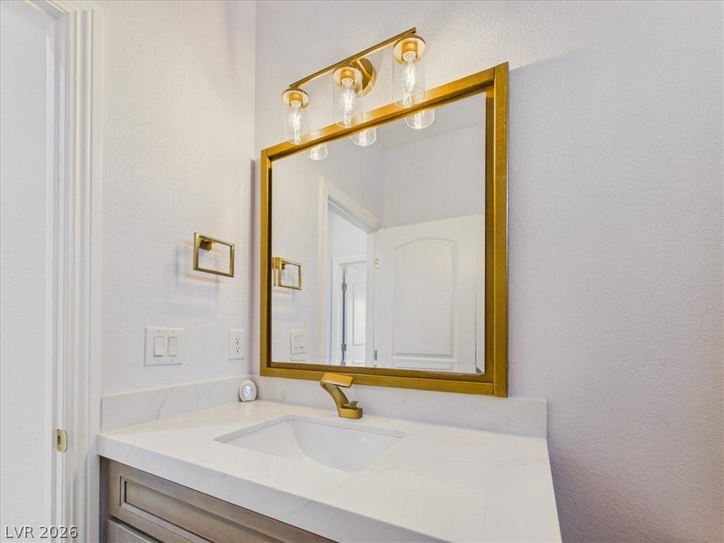 6680 S Raintree Court, Pahrump, NV 89061 Gleaming stone counters paired with a modern undermount sink elevate this half bath.