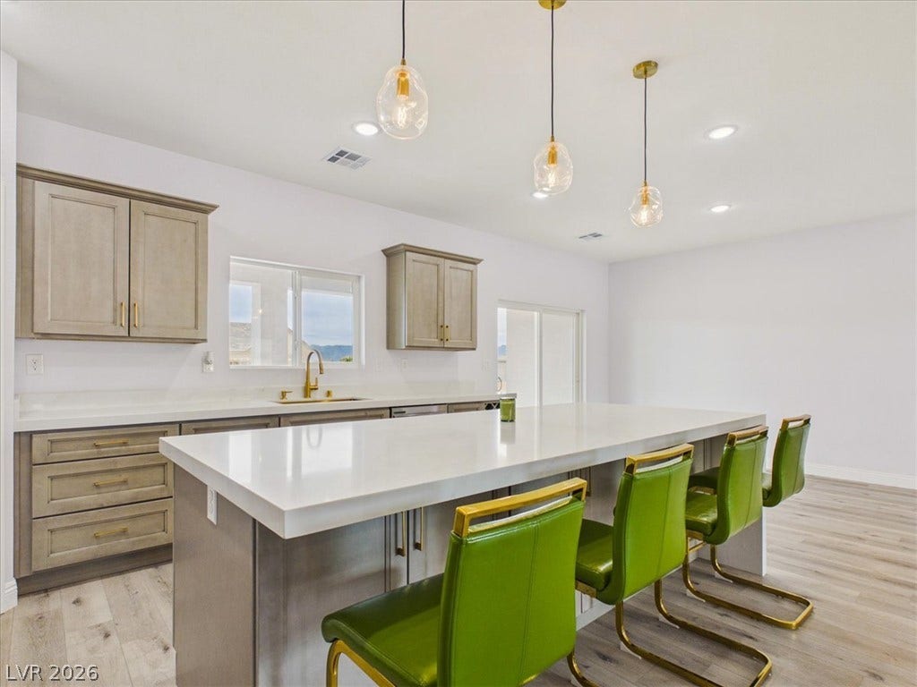 6680 S Raintree Court, Pahrump, NV 89061 Crisp stone countertops and a generous central island anchor this modern kitchen space.
