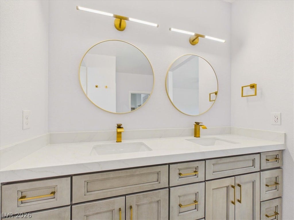 6680 S Raintree Court, Pahrump, NV 89061 A contemporary vanity setup highlights clean stone countertops and sleek modern fixtures.