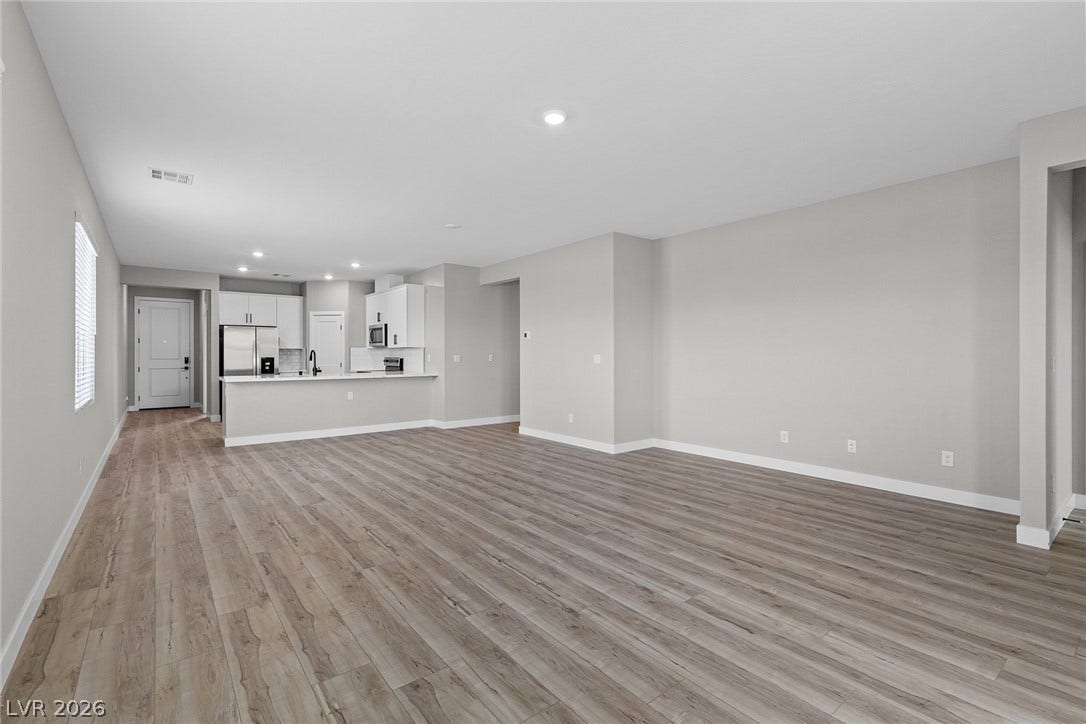 4608 Cave Lake Avenue, North Las Vegas, NV 89032 An open floorplan seamlessly connects the airy living area to a modern, fully equipped kitchen.