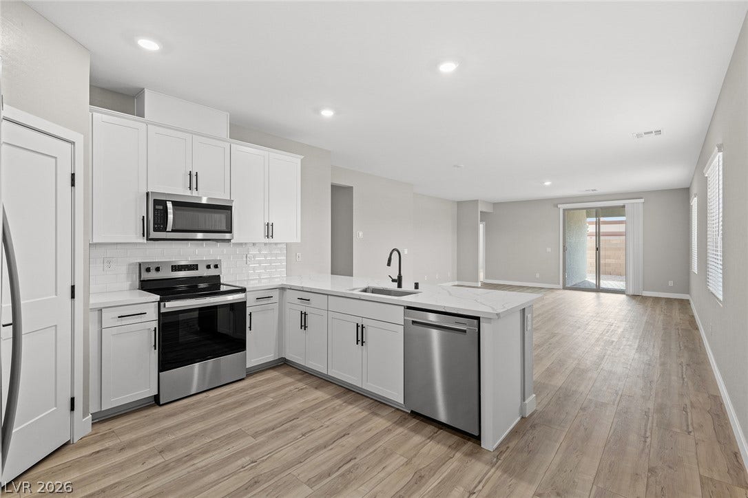 4608 Cave Lake Avenue, North Las Vegas, NV 89032 Clean lines and stone counters highlight this seamless transition from culinary space to living room.