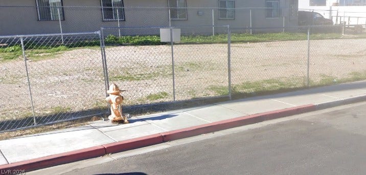 100 W Chicago Avenue, Las Vegas, NV 89102 Secure chain-link fencing borders this level parcel alongside established concrete sidewalks.