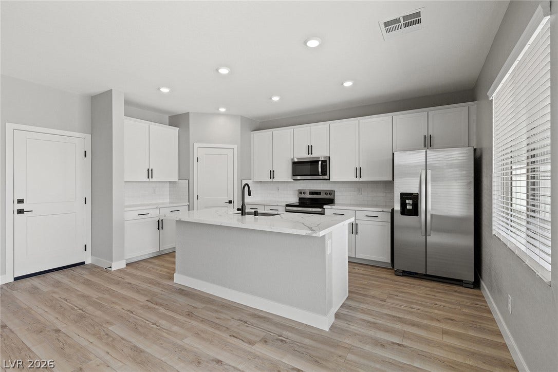 3257 Basin Desert Street, North Las Vegas, NV 89032 Streamlined cabinetry and a central island anchor this modern kitchen with durable hard-surface flooring.