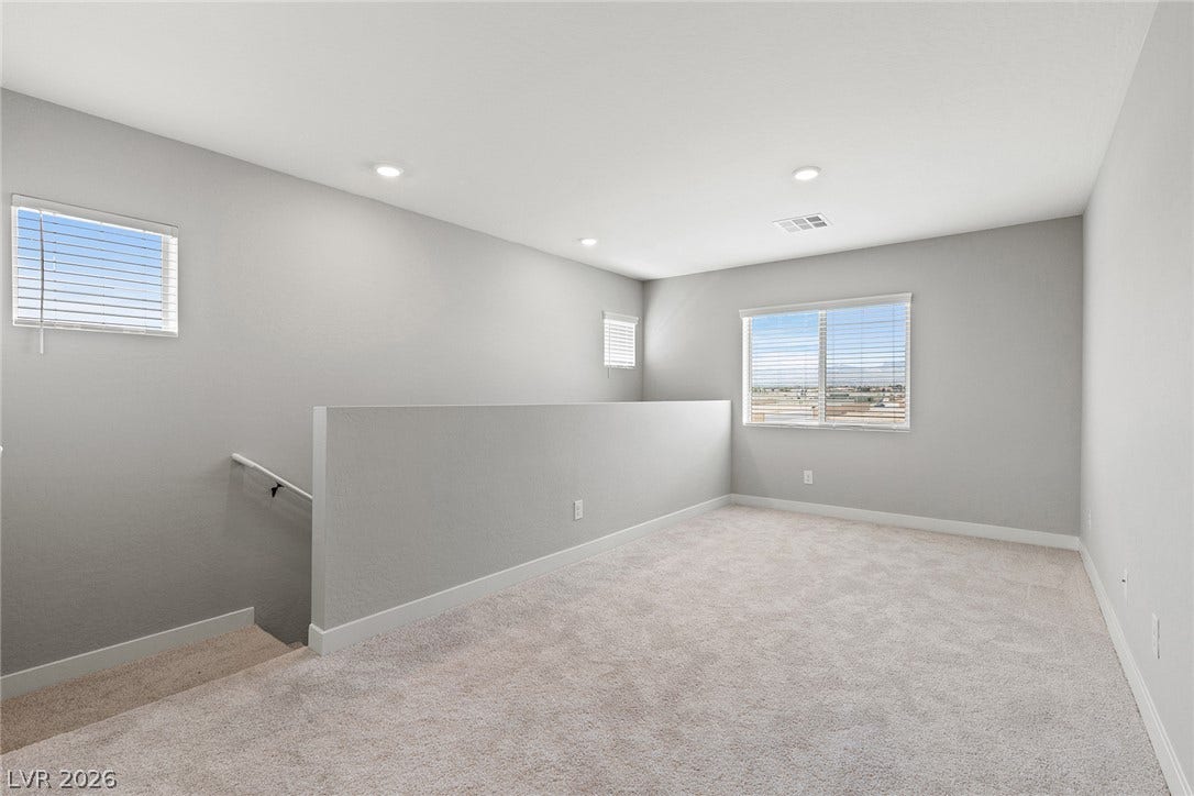 3257 Basin Desert Street, North Las Vegas, NV 89032 Plentiful natural light fills this versatile upper-level loft space featuring plush neutral carpeting.