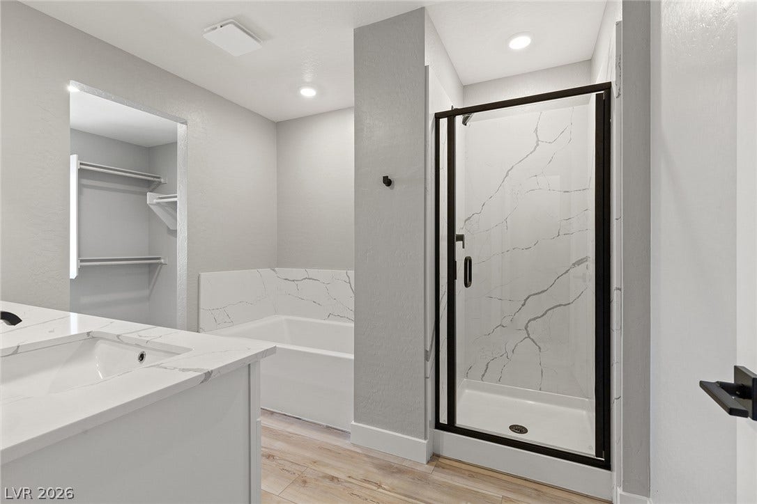 3257 Basin Desert Street, North Las Vegas, NV 89032 A glass-enclosed shower and adjacent soaking tub complement the stone counters and wood-look flooring.