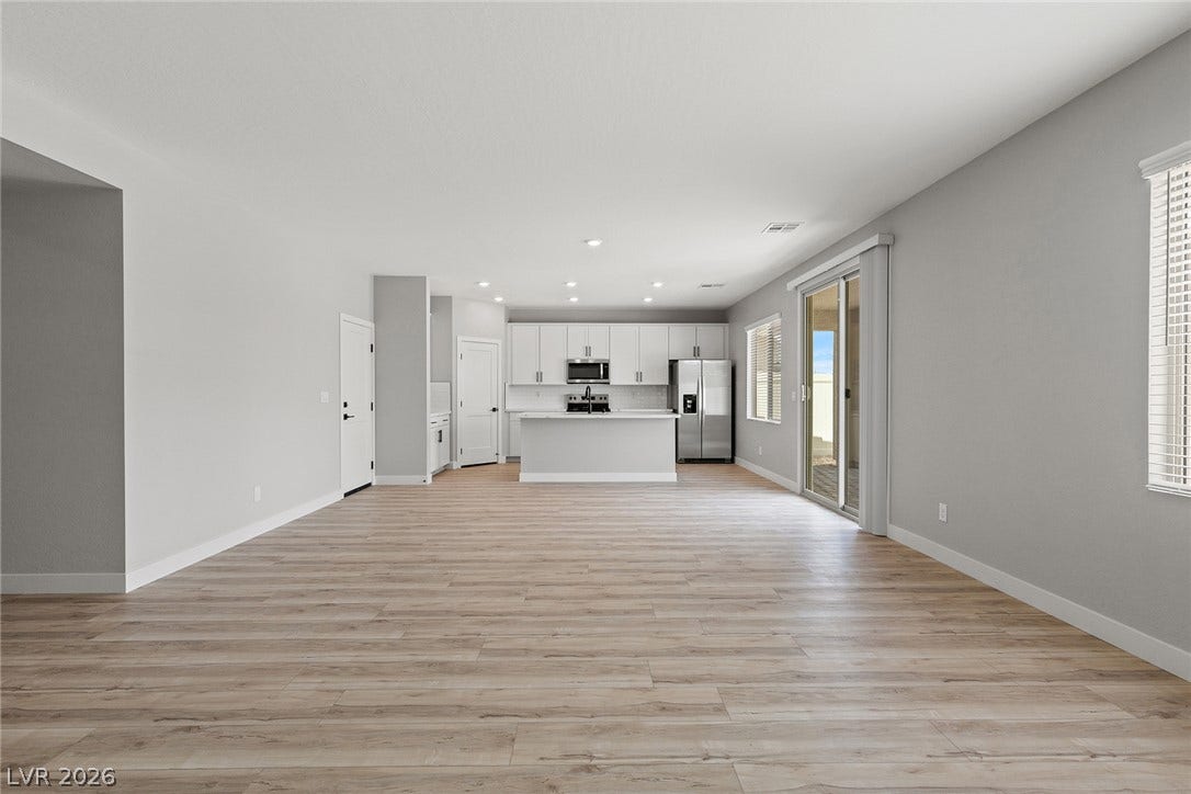 3257 Basin Desert Street, North Las Vegas, NV 89032 An open floorplan connects the main living space to the kitchen featuring wood-inspired flooring.