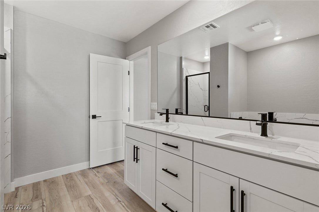 3257 Basin Desert Street, North Las Vegas, NV 89032 A spacious double vanity with stone countertops highlights this modern bathroom space.
