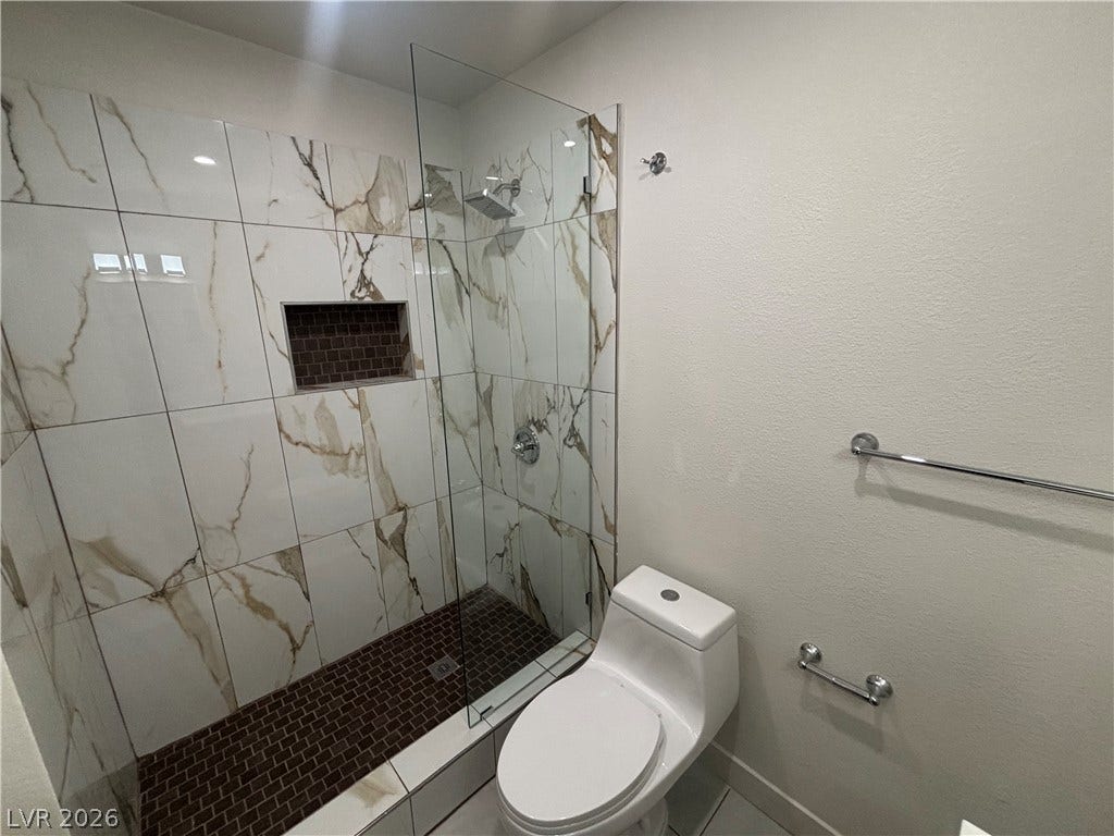 3623 E Biela Avenue, Las Vegas, NV 89120 Custom wall tile and a sleek glass partition elevate this modern walk-in shower design.