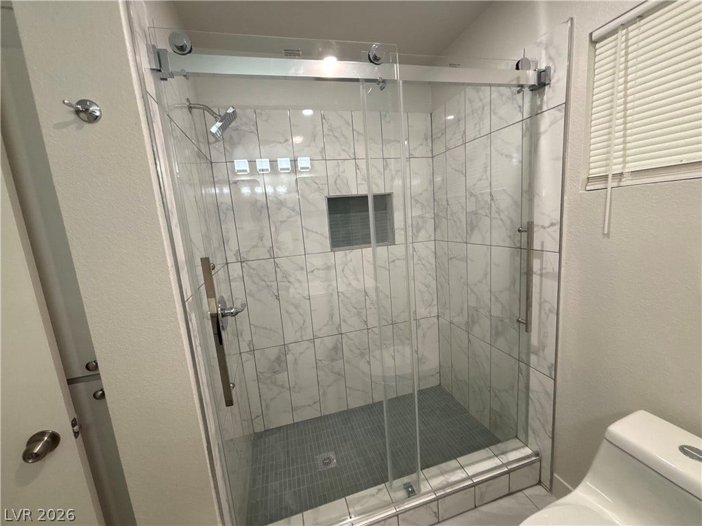 3623 E Biela Avenue, Las Vegas, NV 89120 Floor-to-ceiling marble-patterned tile surrounds a spacious glass-enclosed shower.