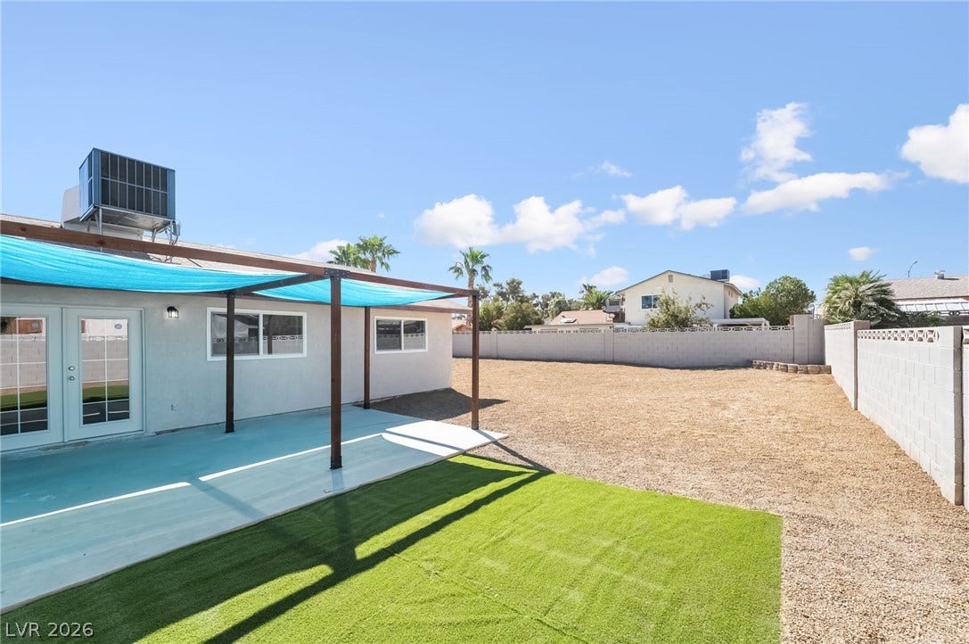 3623 E Biela Avenue, Las Vegas, NV 89120 An expansive backyard with a concrete patio, shaded by a canopy.