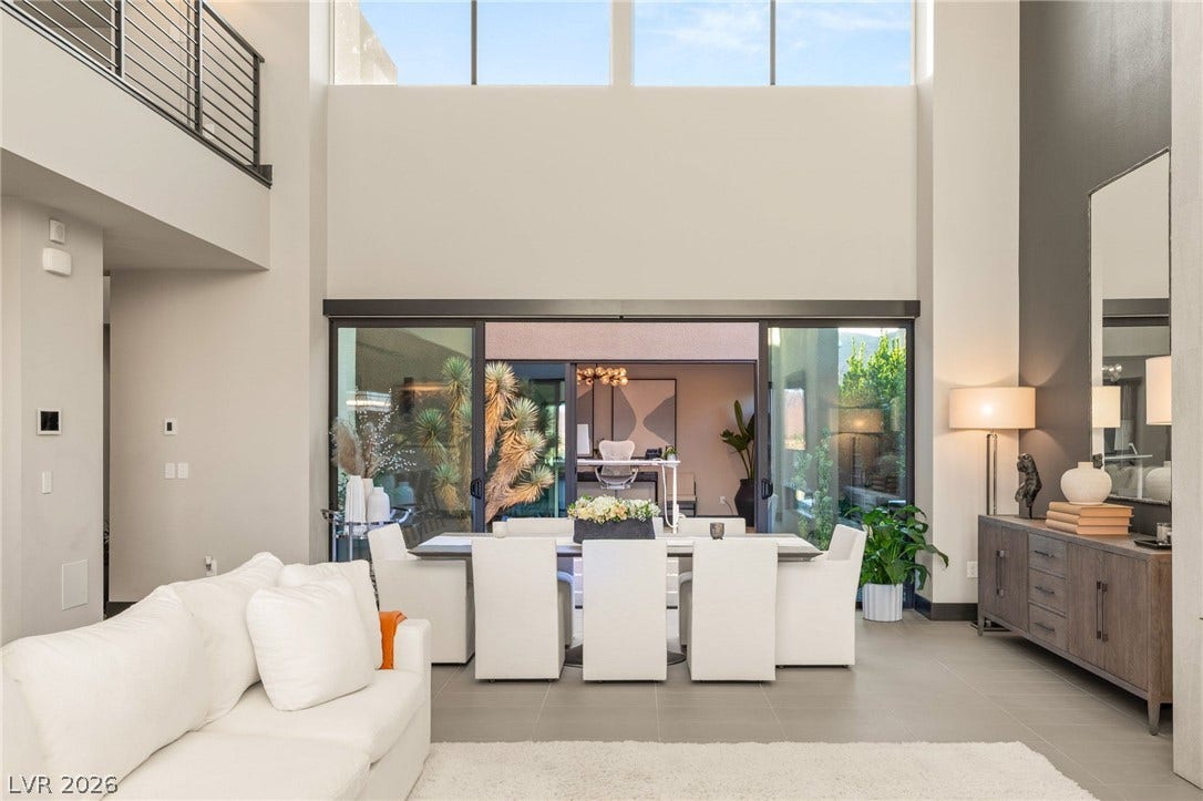 A grand, open-concept living space with soaring ceilings and abundant natural light.