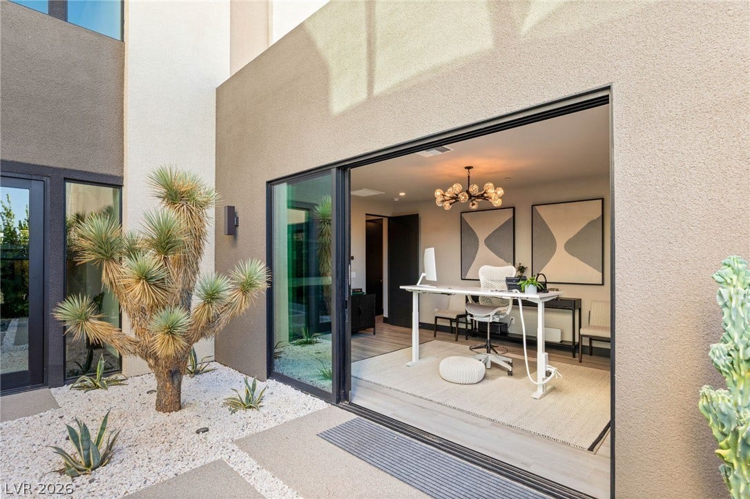 A well-lit, private office space with direct access to a xeriscaped courtyard.