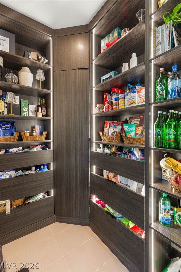 Well-appointed pantry with ample storage, featuring contemporary shelving and integrated lighting for easy access.