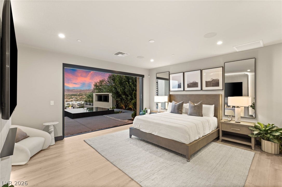 Retreat to a primary suite with wood flooring and direct access to an outdoor area and scenic views.