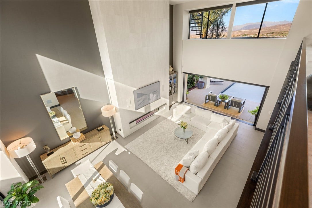 A spacious living room features soaring ceilings and an incredible panoramic view.