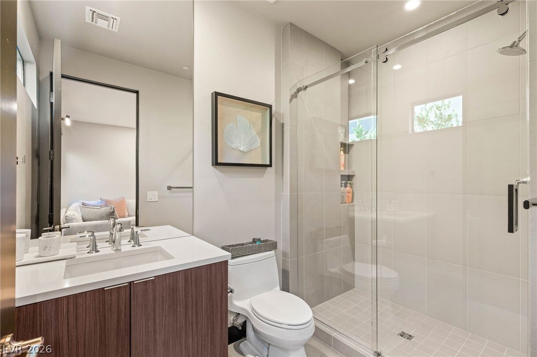 A well-appointed bath features a spacious glass-enclosed shower and a sleek vanity.