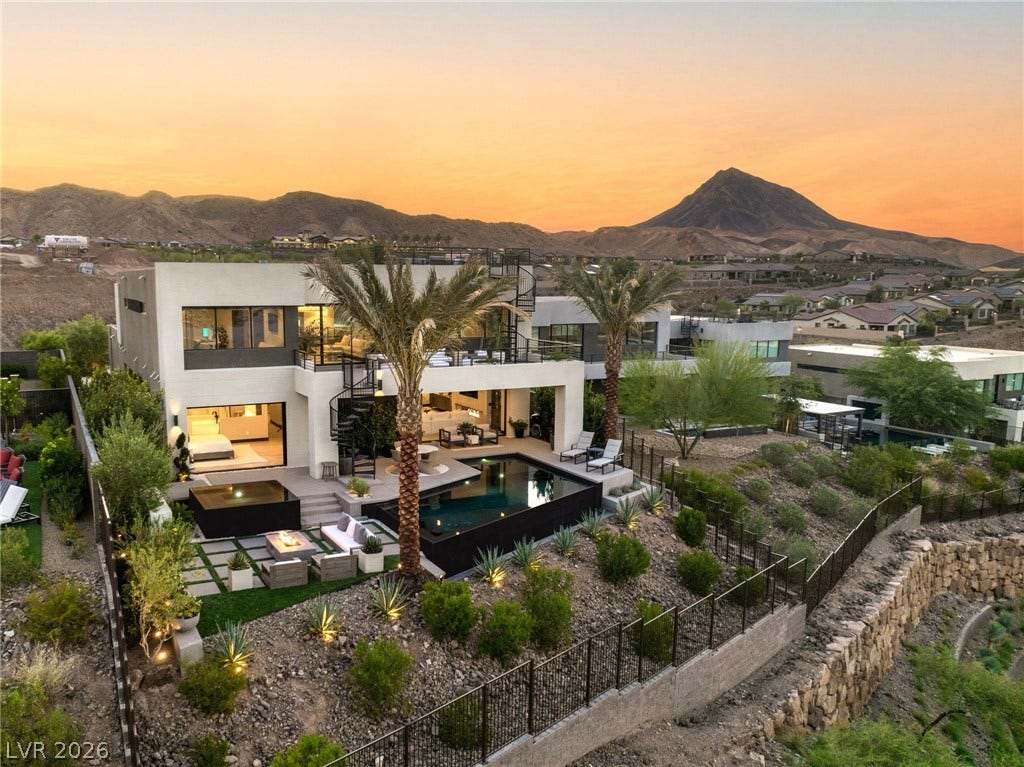 Dramatic mountain views frame this modern residence, complete with a desert-landscaped yard and inviting pool.
