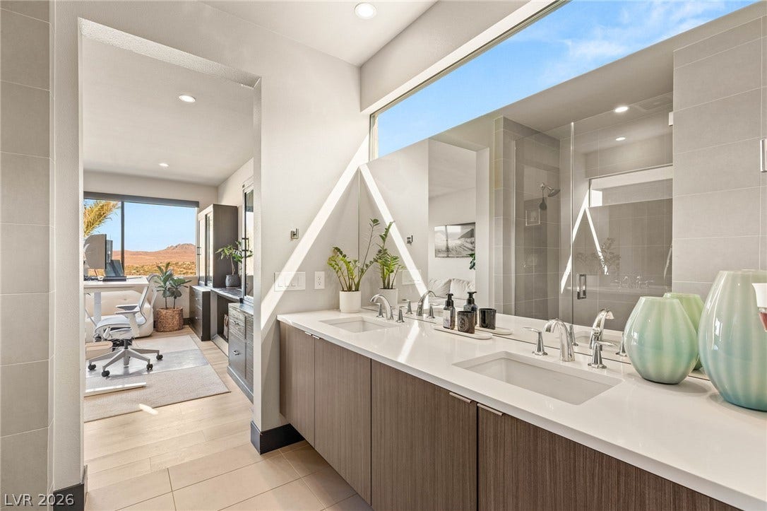 Double vanities and an adjacent office space create a versatile and efficient private retreat.