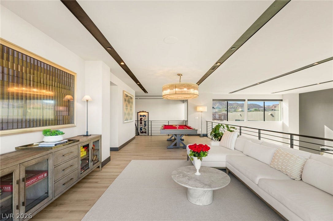 A vibrant recreation room features a billiard table and a comfortable sitting area with scenic views.