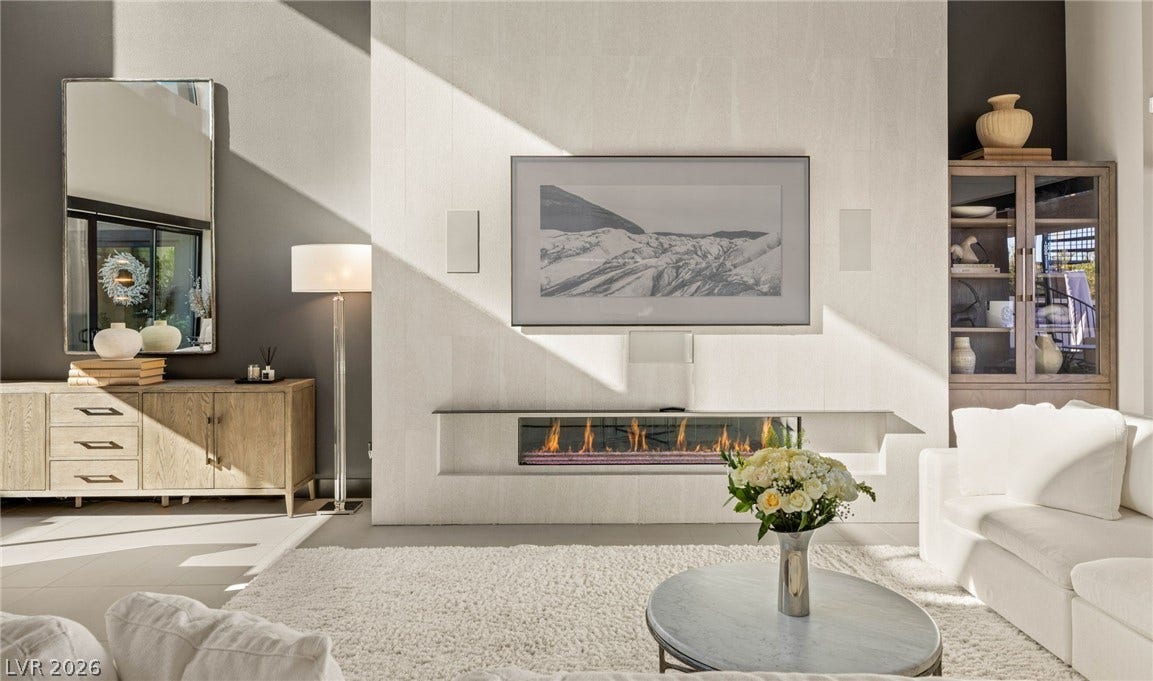 A well-lit interior showcases a contemporary fireplace, sleek finishes, and inviting lounging space.