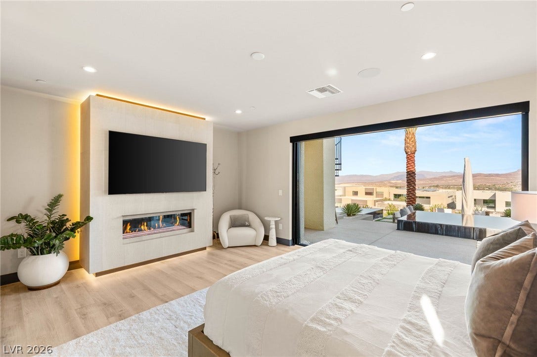 A spacious primary bedroom features an elegant fireplace and direct access to an outdoor patio with mountain views.