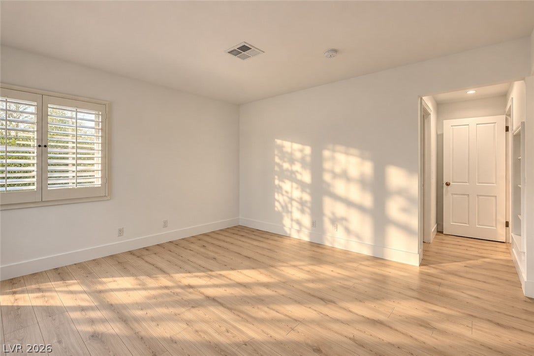 2001 Silver Avenue, Las Vegas, NV 89102 Warm afternoon light streams across smooth plank flooring in this airy, minimalist bedroom space.